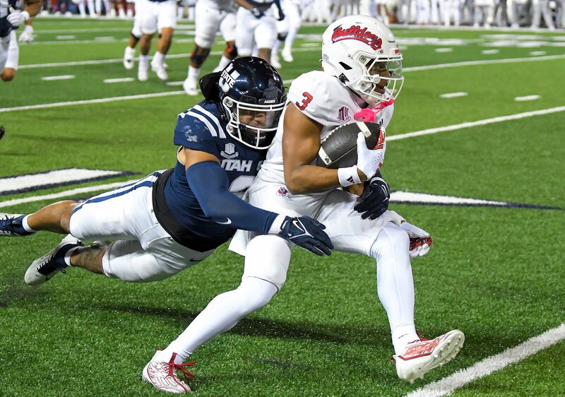 Fresno State’s Erik Brooks tries to get away from Utah State linebacker MJ Tafisi Jr. during game, Oct. 13, 2023, in Logan.