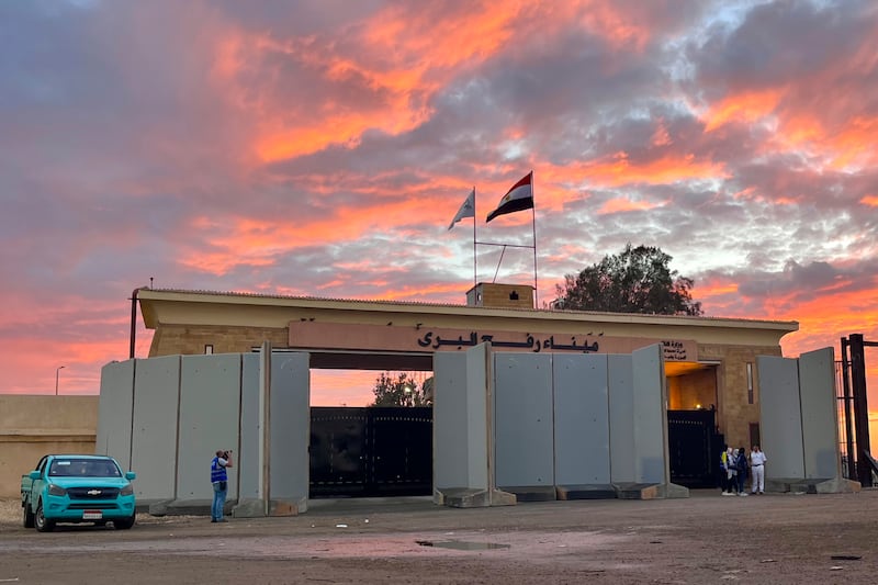 Policemen stand at Rafah crossing port, Egypt, as humanitarian aid convoy for the Gaza Strip is parked Tuesday, Oct. 17, 2023.