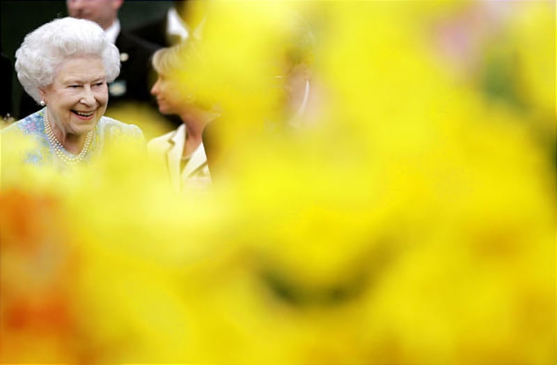 Britain’s Queen Elizabeth II walks past flowers as she visits gardens at the Chelsea Flower Show in London on May 24, 2010.