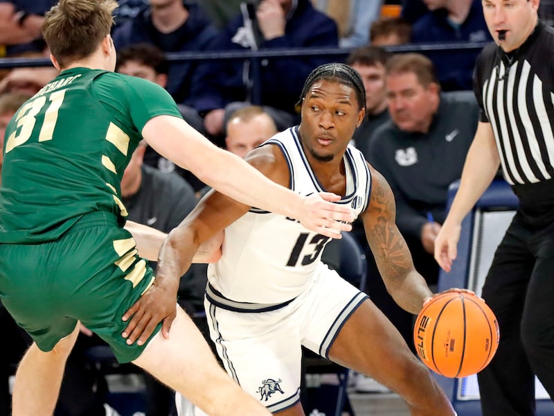 Utah State’s Deyton Albury (13) drives around Charlotte forward Nick Richart during the Aggies’ 103-74 win on Nov. 9, 2024, at the Spectrum in Logan.