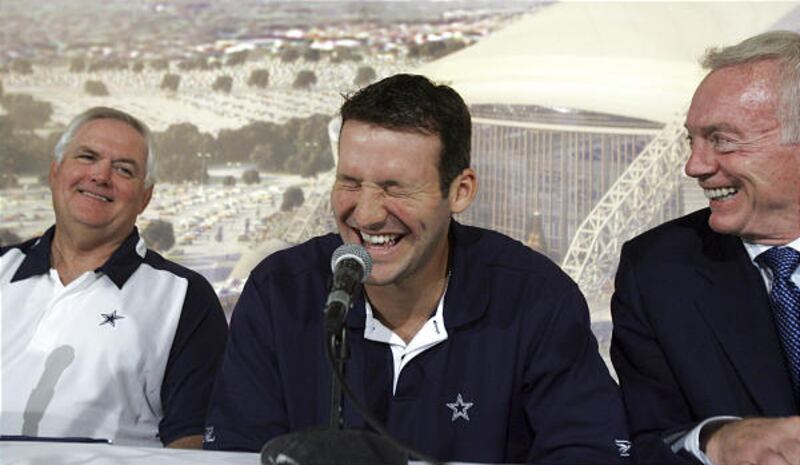 Dallas quarterback Tony Romo, center, signed a six-year, $67 million contract extension with the Cowboys on Tuesday.