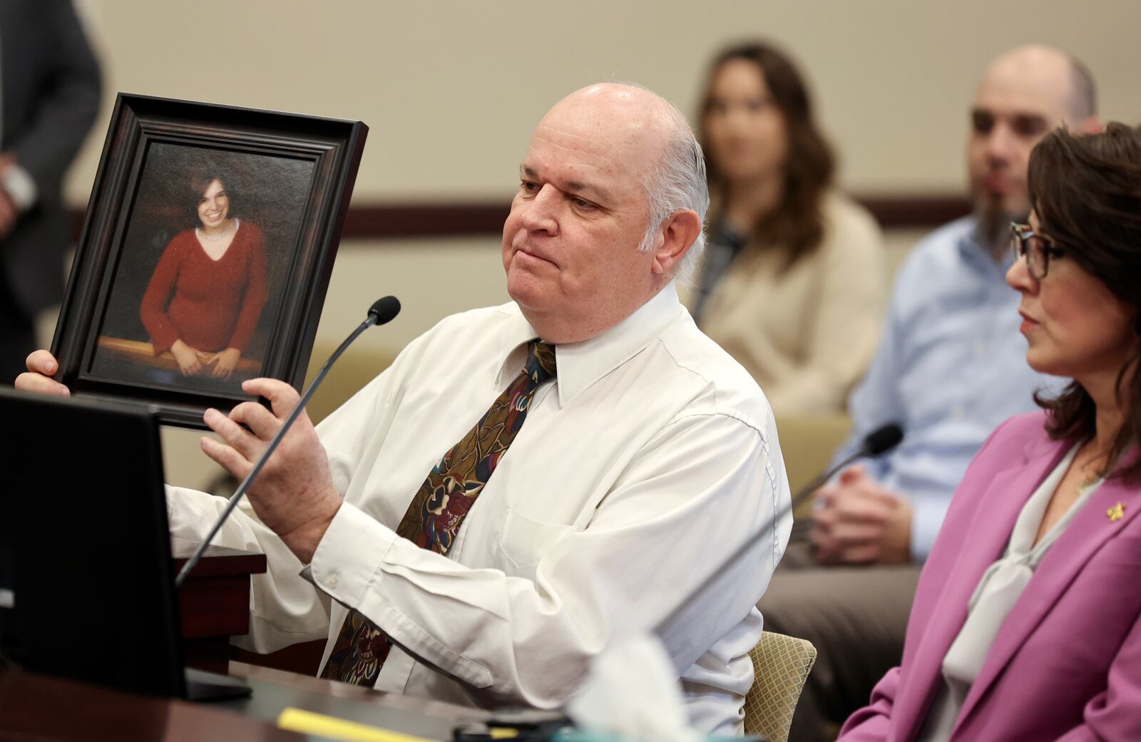 Kent Mayne holds up a photo of his daughter Mandy, who was killed by her ex-husband, as he speaks in support of SB117 on Jan. 24, 2023.