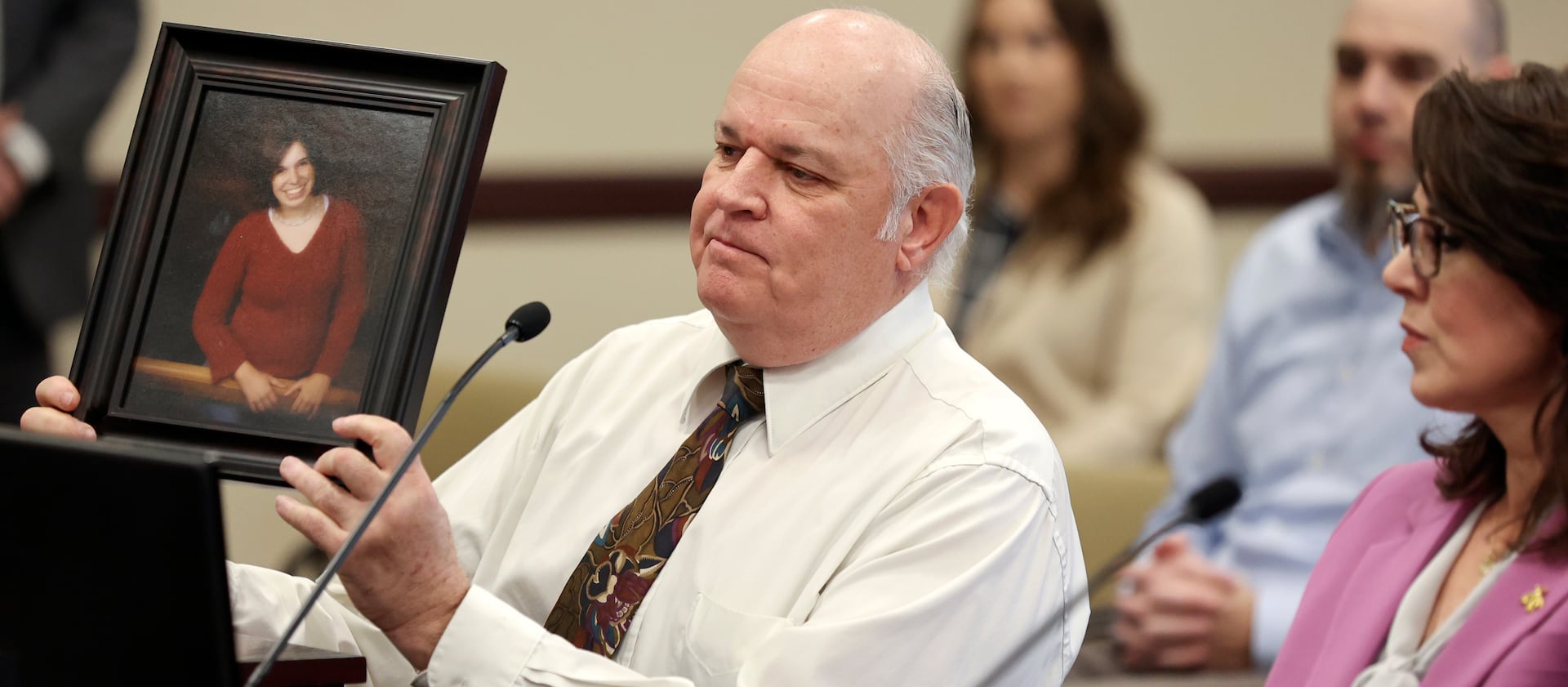 Kent Mayne holds up a photo of his daughter Mandy, who was killed by her ex-husband, as he speaks in support of SB117 on Jan. 24, 2023.