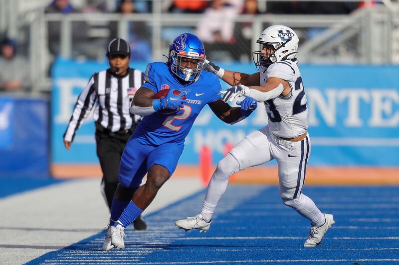 Boise State running back Ashton Jeanty (2) runs down the sideline as Utah State linebacker Kaleo Neves (23) comes in for the tackle attempt in the first half of an NCAA college football game, Friday, Nov. 25, 2022, in Boise, Idaho. (AP Photo/Steve Conner)
