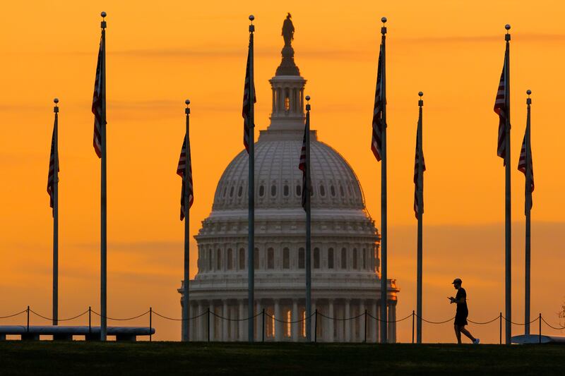 The U.S. Capitol Building looms behind flags on the National Mall in Washington.