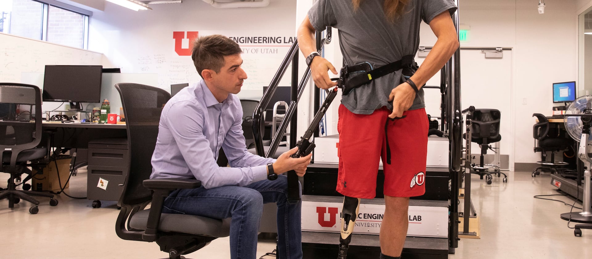 University of Utah assistant professor Tommaso Lenzi helps Alec McMorris put on an experimental exoskeleton.