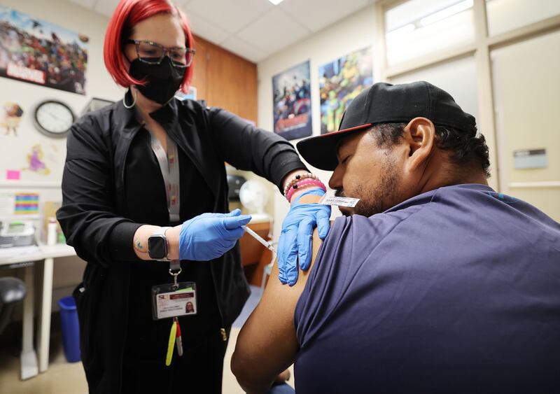 Hugo Varguez receives a COVID-19 vaccine from nurse Leila Callaway at the Salt Lake County Health Center.