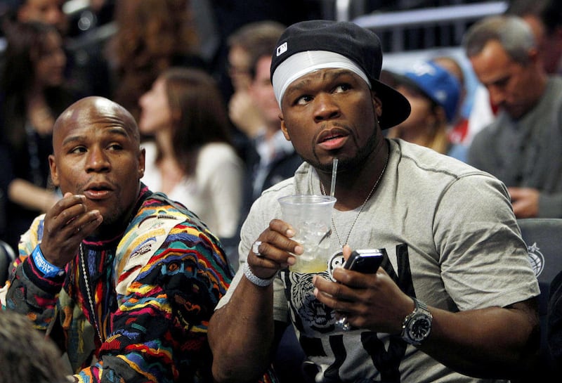 Boxer Floyd Mayweather Jr, left, and performer 50 Cent sit courtside during the NBA All-Star Shooting Stars basketball competition in Orlando, Fla., Saturday, Feb. 25, 2012.