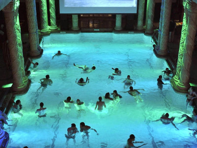 FILE - In this Dec. 5, 2008 file picture guests enjoy the night bathing and the silent film screening with background music in the Gellert Thermal Bath illuminated by colored lights during the first 'Night of Waters' event in Budapest, Hungary. A German i