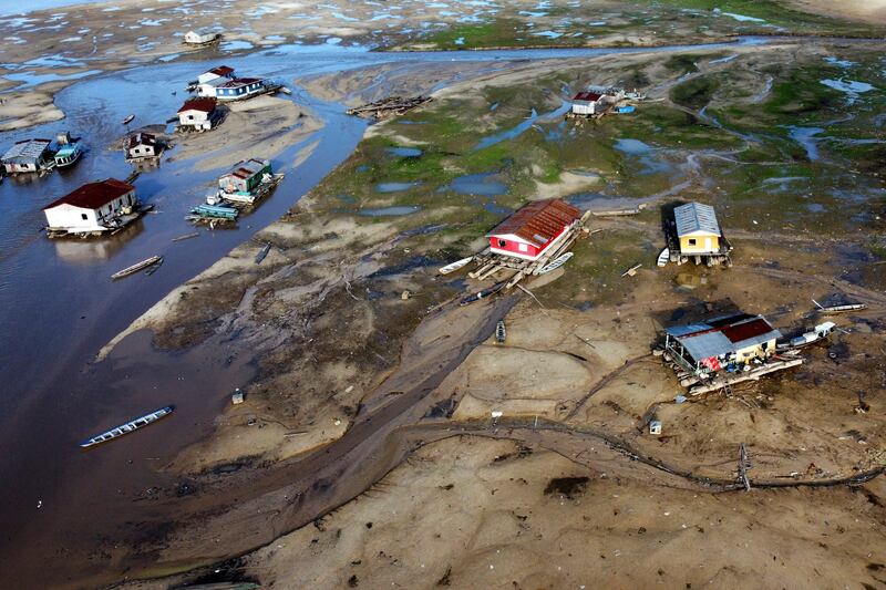 Houseboats sit on land affected by drought near the Solimoes River, in Tefe, Amazonas state, Brazil, on Oct. 19, 2022.