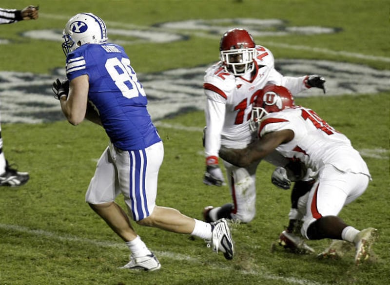 BYU tight end Andrew George (88) catches a pass between Utah defensive back Joe Dale (12) and Utah linebacker Stevenson Sylvester (10) and runs in for the score giving BYU the win in overtime 26-23 in November.