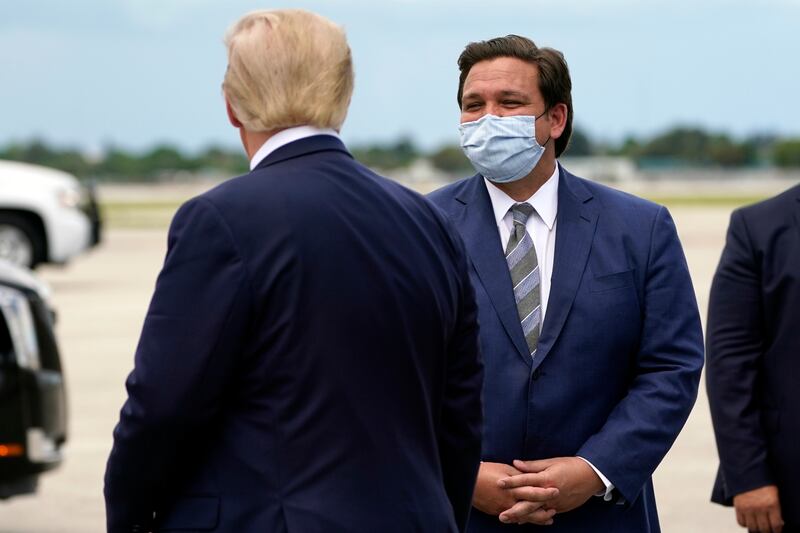 Former President Donald Trump greets Florida Gov. Ron DeSantis in West Palm Beach, Florida.