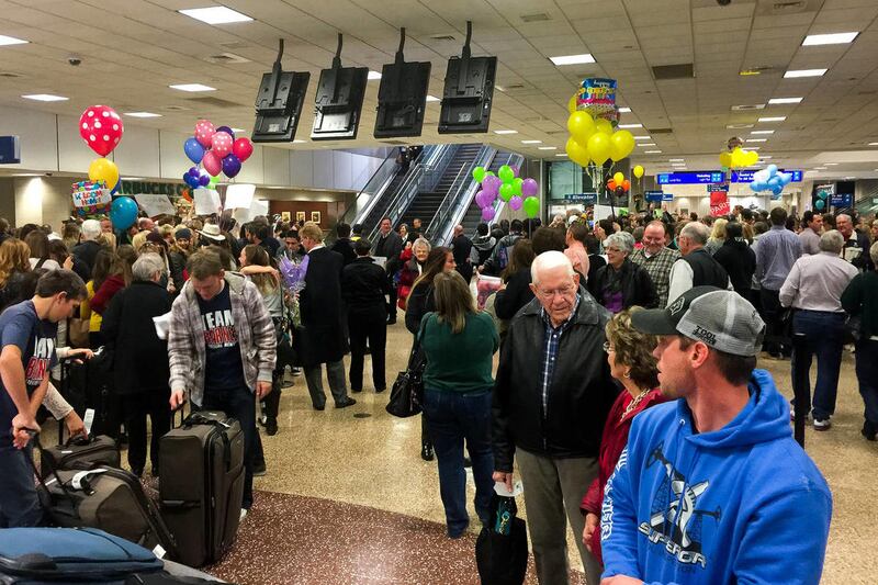 In this photo taken on Wednesday, Dec. 17, 2014, families and friends welcome home missionaries at the Salt Lake International Airport.