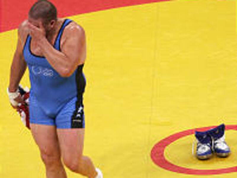 Rulon Gardner leaves after taking off his shoes to mark his retirement after defeating Sajad Barzi for bronze medal.