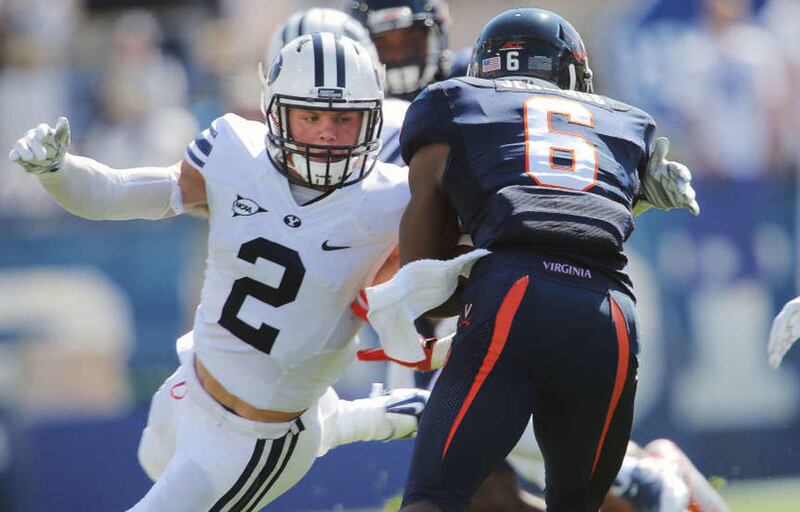 Brigham Young defensive back Dallin Leavitt (2) looks to tackle Virginia wide receiver Darius Jennings (6) as BYU and Virginia play Saturday, Sept. 20, 2014, at LaVell Edwards Stadium in Provo.