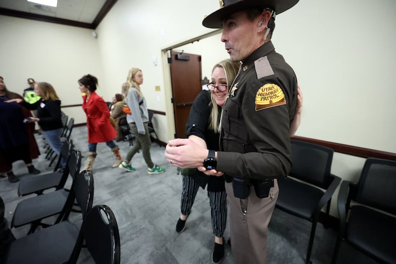A woman hugs a UHP Trooper after SB88 was held after residents showed up to express feelings on digital driver license amendments in the House Public Utilities, Energy and Technology Committee hearing in the Senate Building.