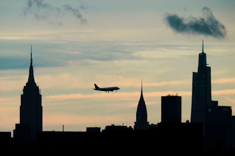 An airplane flies over the New York skyline in midtown Manhattan.