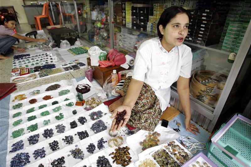 A Myanmar woman sells semi-precious stones at a market in Mae Sot, Thailand. Activists call Myanmar's prized gems "blood rubies."