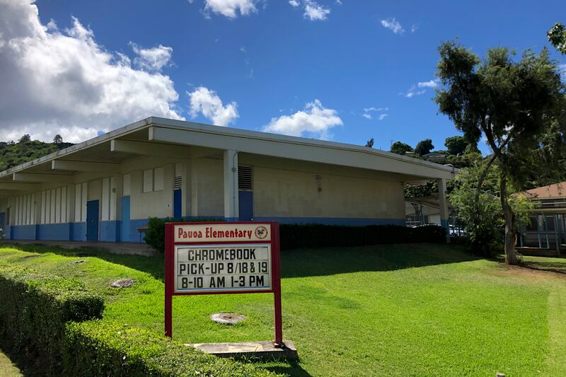 A sign at Pauoa Elementary School in Honolulu on Monday, August 17, 2020, informs students when to pick-up computers for distance learning. Many Hawaii public school students are spending the first day of school online as coronavirus cases surge, mostly on the island of Oahu, where Honolulu is located.