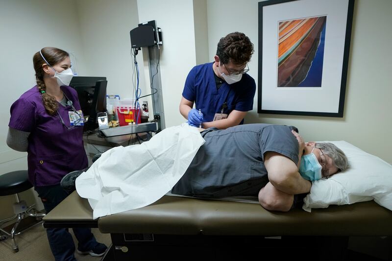 Ray Hoffman, right, who is immunocompromised, is given a shot of the two-shot dose of AstraZeneca’s Evusheld.