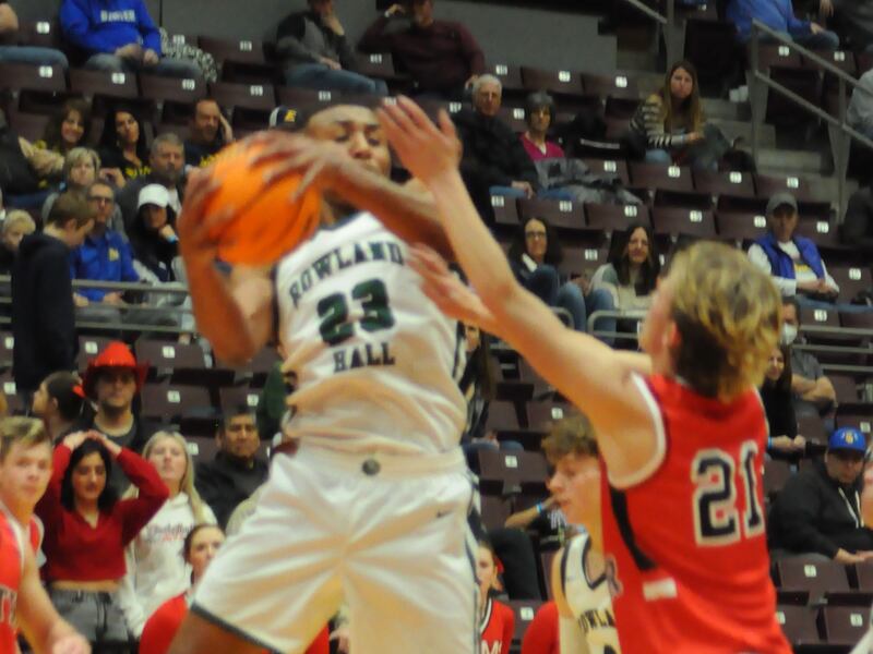 Rowland Hall’s Samuel Andrew snags a rebound while South Sevier’s Keagan Heath applies pressure.