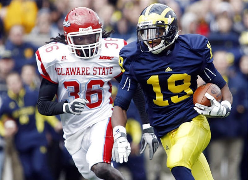 Michigan slot receiver Kelvin Grady runs the ball in for a touchdown as Delaware State cornerback Francis Adjei (36) defends during the first quarter of an NCAA college football game, Saturday in Ann Arbor, Mich.