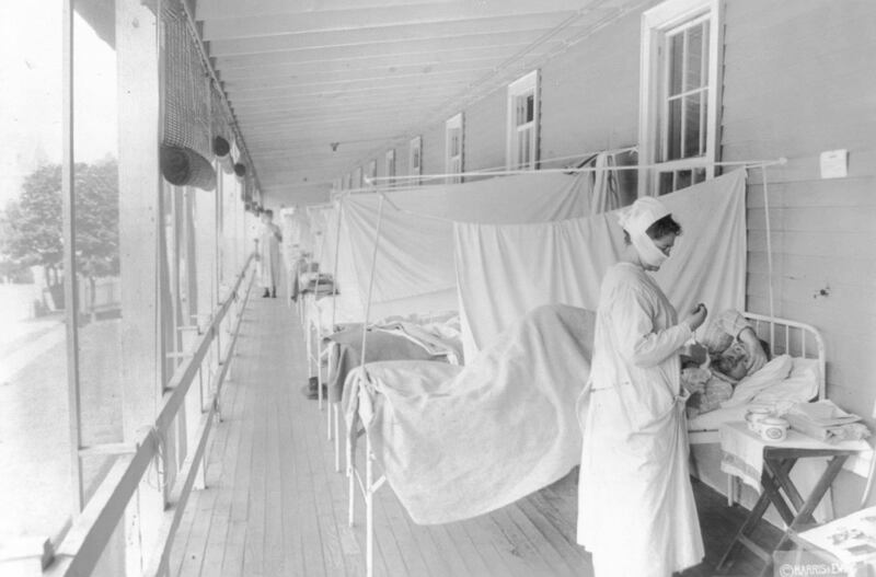 In this November 1918 photo made available by the Library of Congress, a nurse takes the pulse of a patient in the influenza ward of the Walter Reed hospital in Washington. Science has ticked off some major accomplishments over the last century.