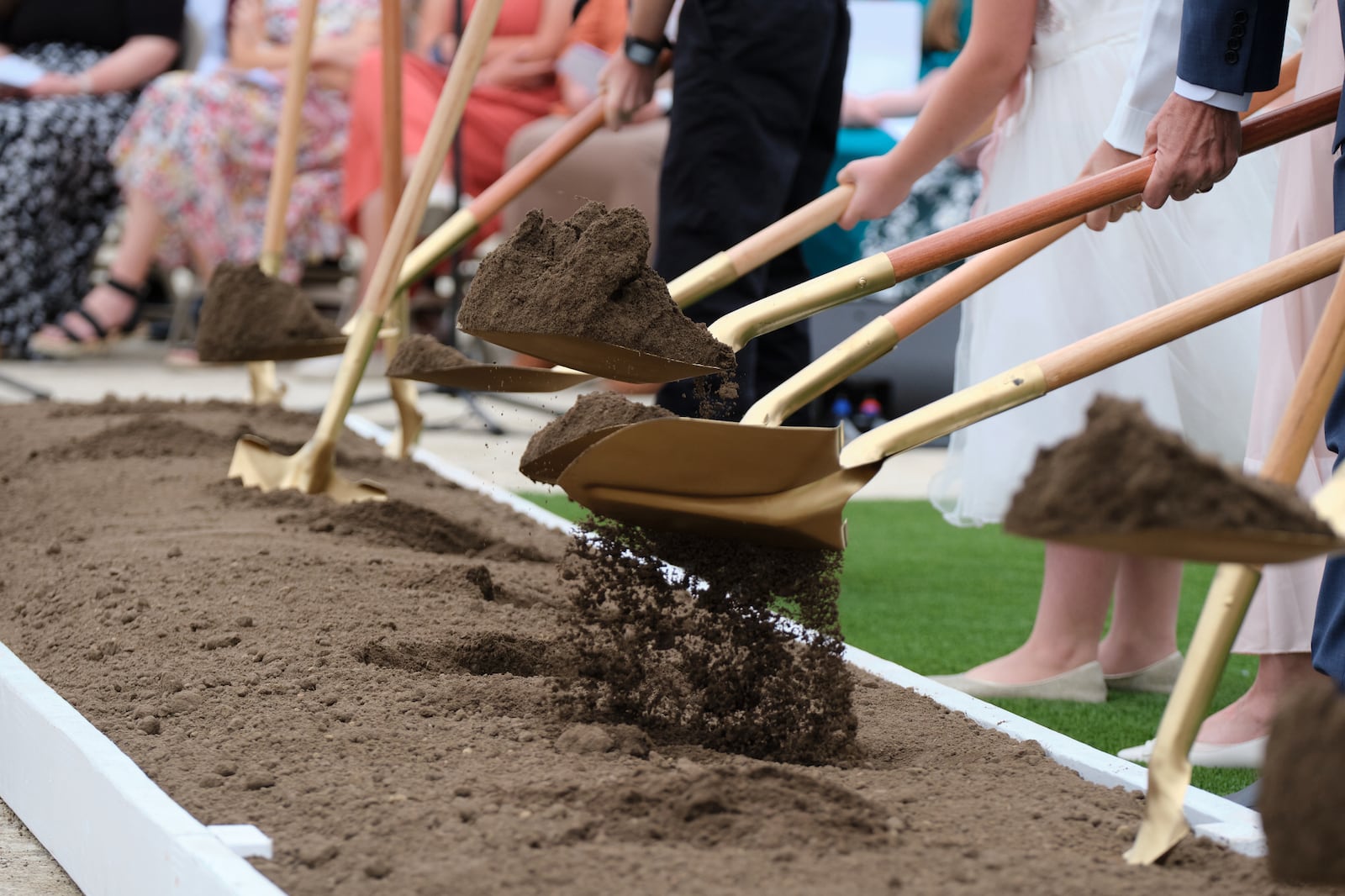 Shovelfuls of dirt commemorate breaking ground for the Wichita Kansas Temple .