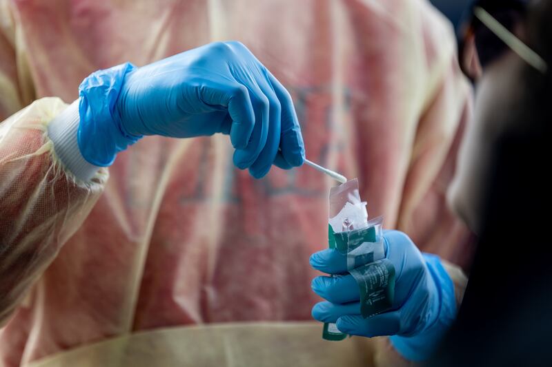 Health care worker Bob Ekoh administers a COVID-19 test at City Hall in Herriman.
