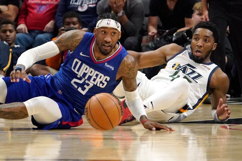 Los Angeles Clippers forward Robert Covington, wearing blue and Utah Jazz guard Donovan Mitchell scramble for a loose bal