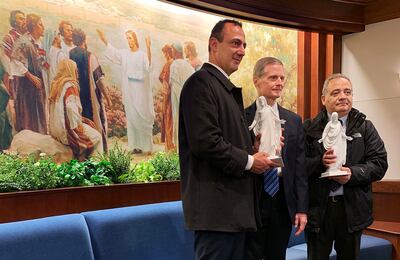 Elder David A. Bednar of the Quorum of the Twelve Apostles of The Church of Jesus Christ of Latter-day Saints, center, presents gifts of a Christus figurine to President Marcello De Vito, left, president of the Rome City Council, and President Giovanni Ca