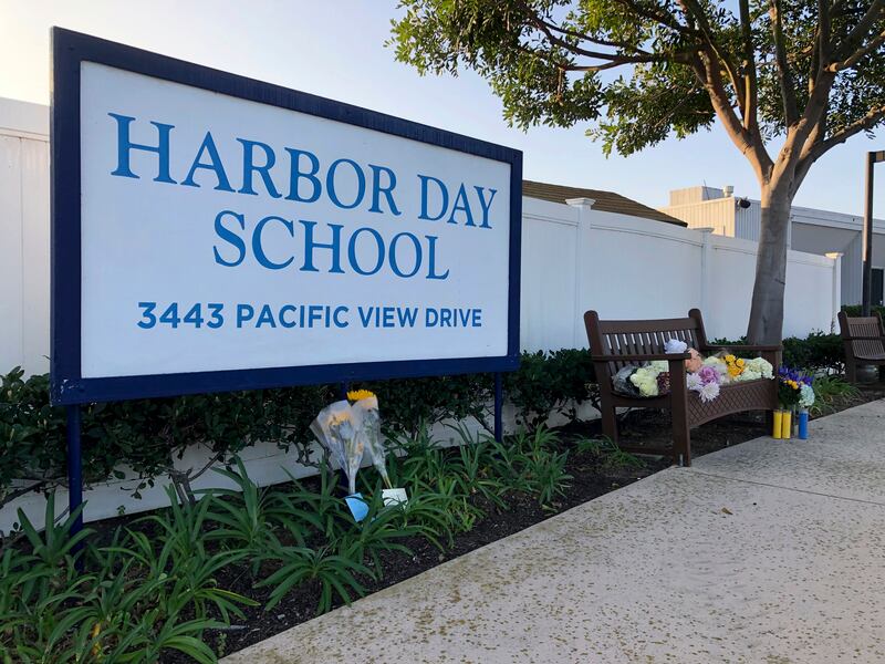 Flowers and messages are placed in front of Harbor Day School, a private elementary school in Corona Del Mar, Calif., Monday, Jan. 27, 2020.