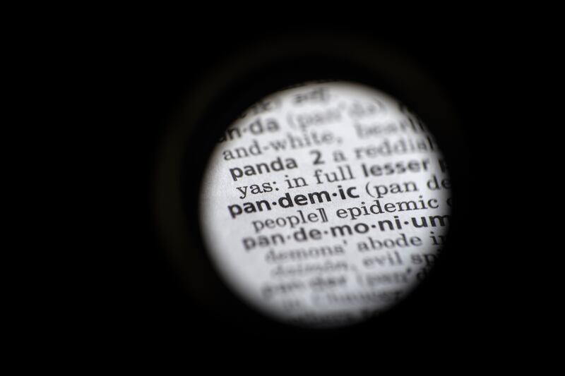 In this Saturday, Nov. 21, 2020, photo taken through a camera lens the word “pandemic” in seen in a dictionary in Washington. Dictionary.com declared “pandemic” its 2020 word of the year.