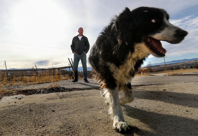 Governor of Utah, Spencer Cox, stands behind his dog, Shadow, on the family’s farmland in Sanpete County in December 2020.