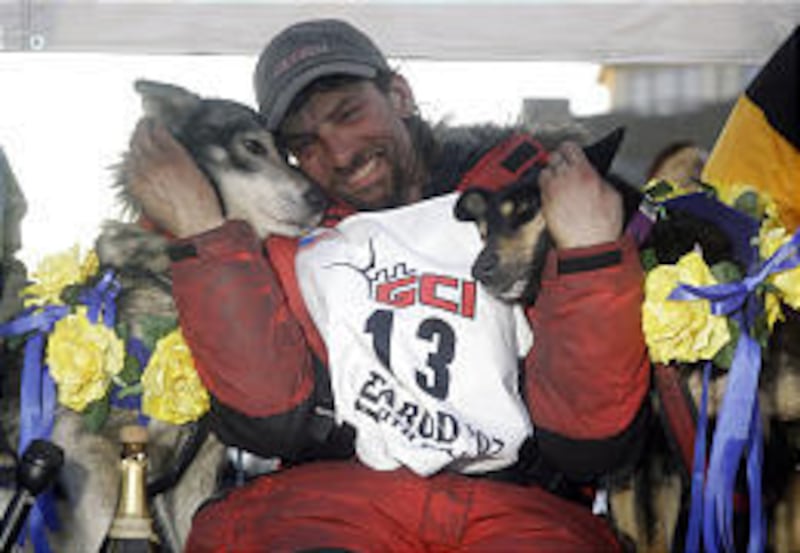 Lance Mackey of Fairbanks, Alaska, hugs his lead dogs Larry, left, and Lippy after his Iditarod Trail Sled Dog Race victory in Nome, Alaska, on Tuesday. Mackey, a cancer survivor, is a repeat champion.