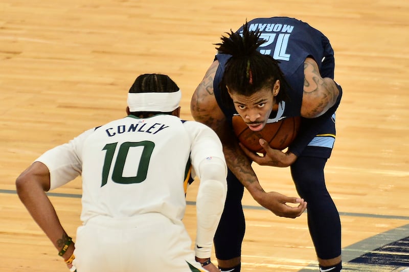 Memphis guard Ja Morant handles the ball against Utah Jazz guard Mike Conley in an NBA playoff game in Memphis, Tenn.