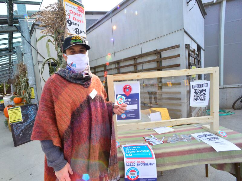 Jon Megas, the marketing and community relations manager for the Brattleboro Food Co-op, in Brattleboro, Vt., helps register people to vote outside of the Co-op during a National Voter Registration Day on Tuesday, Sept. 22, 2020.