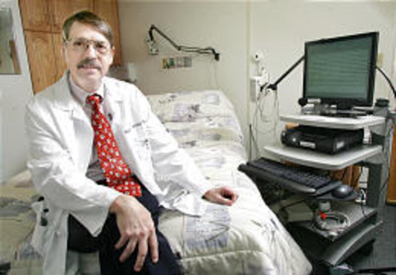 Dr. Robert Farney sits in a sleep-test room at LDS Hospital. He'll field hotline questions about sleeping problems Saturday.