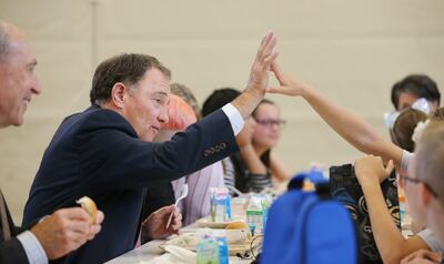 Gov. Gary Herbert high-fives a student while eating lunch at Rose Springs Elementary School in Stansbury Park on Wednesday, Aug. 22, 2018. During his visit, Herbert looked over school safety measures and met with Tooele County School District counselors t