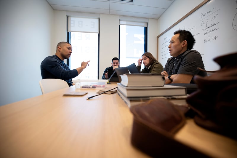 James Curran, founder and CEO of Whistlepitch, a technology company, Chris Barragan, J Lyons, and James Choi, talk in a meeting.