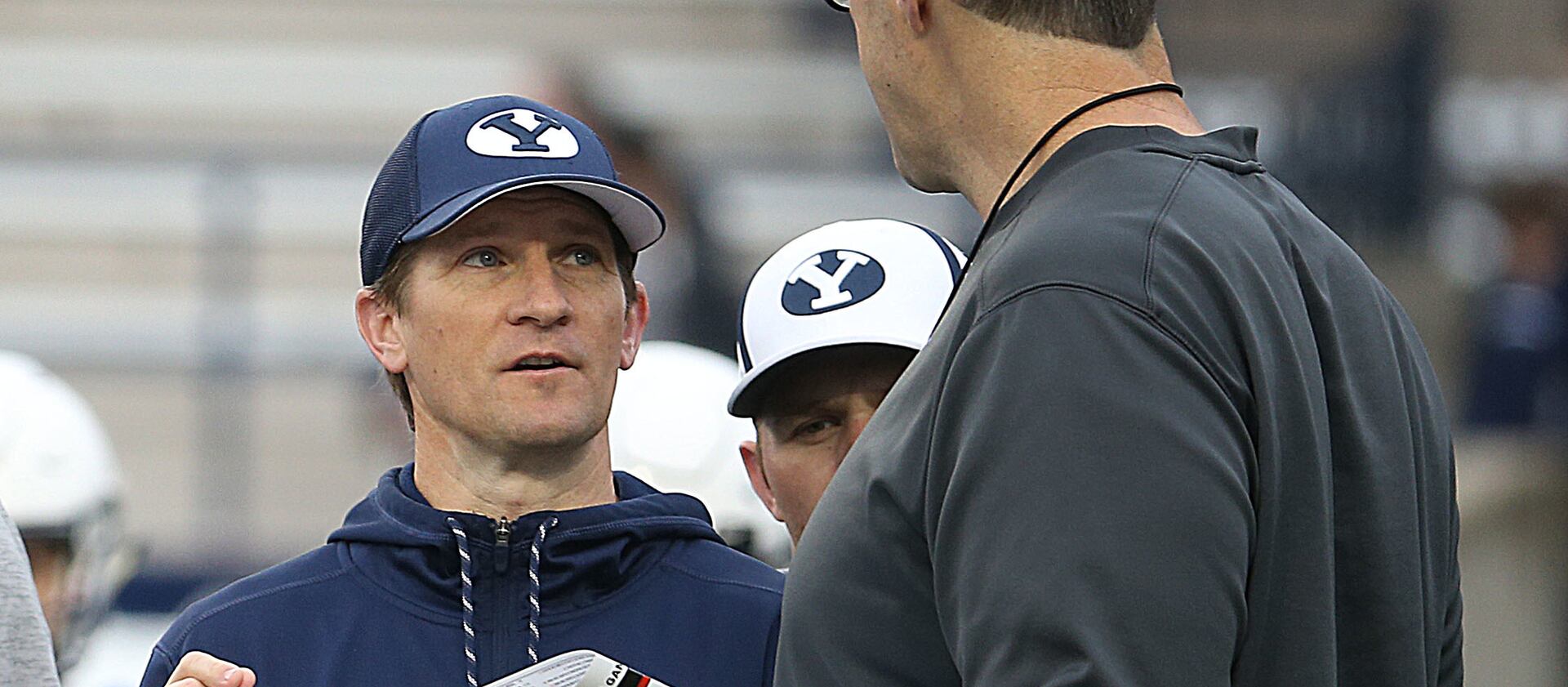 QB coach Aaron Roderick, left and offensive coordinator Jeff Grimes, right, confer during the Blue-White Game at LaVell Edwards Stadium in Provo on Saturday, April 7, 2018.