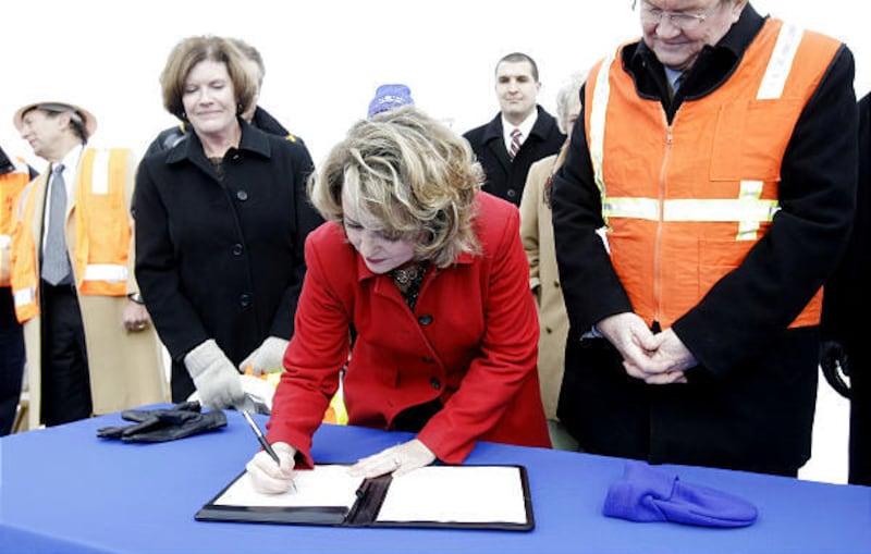 Acting administrator of the FTA Sherry E. Little signs a check for more than $400 million at a press conference in Midvale on Friday.