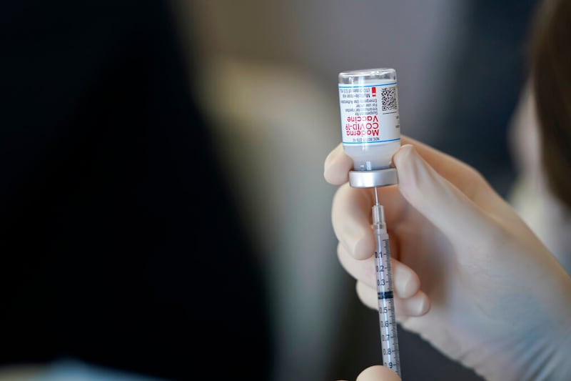 Worker uses Moderna COVID-19 vaccine.