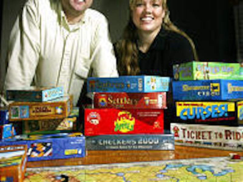 Game gurus Travis and Amy Oliphant display some of the board games they distribute. Games Unplugged carries about 450 titles.