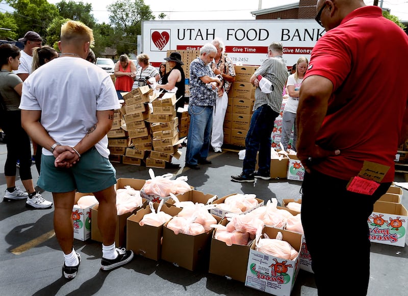 Volunteers pray before handing out food at the Utah Food Bank mobile pantry at The Church of Jesus Christ of Latter-day Saints Cannon Stake Center in Salt Lake City in 2021.
