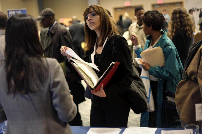 FILE - In this April 18, 2011 file photo, a woman at a job fair in New York talks to an employer. For the first time, American women have passed men in gaining advanced college degrees as well as bachelor's degrees, part of a trend that is helping redefin