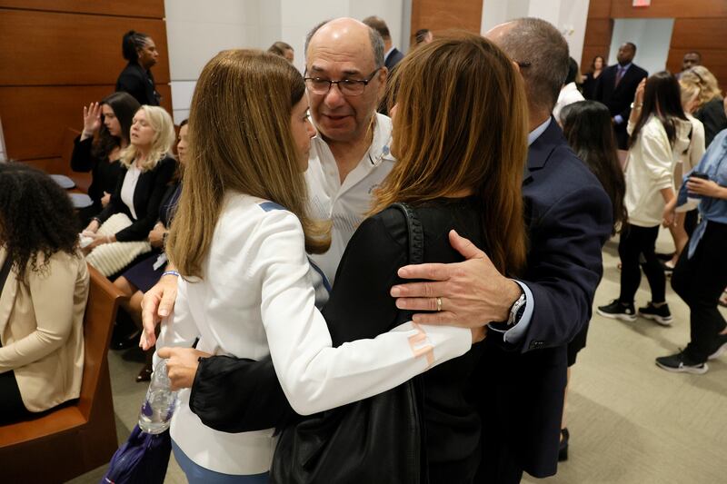 Linda Beigel Schulman, Michael Schulman, Patricia Padauy Oliver and Fred Guttenberg, families of the victims, embrace in the courtroom.