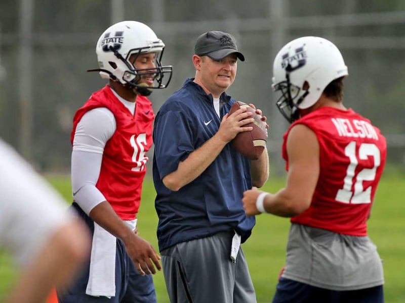 New offensive coordinator Josh Heupel is framed between quarterbacks Chuckie Keeton, left, and DJ Nelson during Utah State football practice Aug. 7, 2015, in Logan.