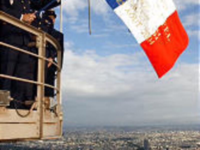 Firefighter Robert Duriaux, son of Henri Duriaux who hoisted the French flag atop the Eiffel Tower on Aug. 25, 1944, after four years of Nazi occupation, hoists the flag atop the Eiffel Tower Wednesday.