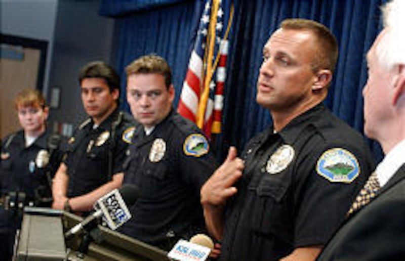 Sandy officer Bill O'Neal imitates how Elizabeth Smart's heart was pounding when he questioned her. With him are officers Karen Jones, Victor Quezada and Troy Rasmussen. Sandy Police Chief Stephen Chapman is at right.